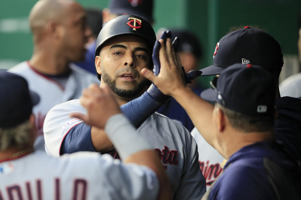 Minnesota Twins designated hitter Nelson Cruz is congratulated by teammates after his solo home run in the eighth inning of a baseball game against the Kansas City Royals at Kauffman Stadium in Kansas City, Mo., Saturday, Sept. 28, 2019. (AP Photo/Orlin Wagner)