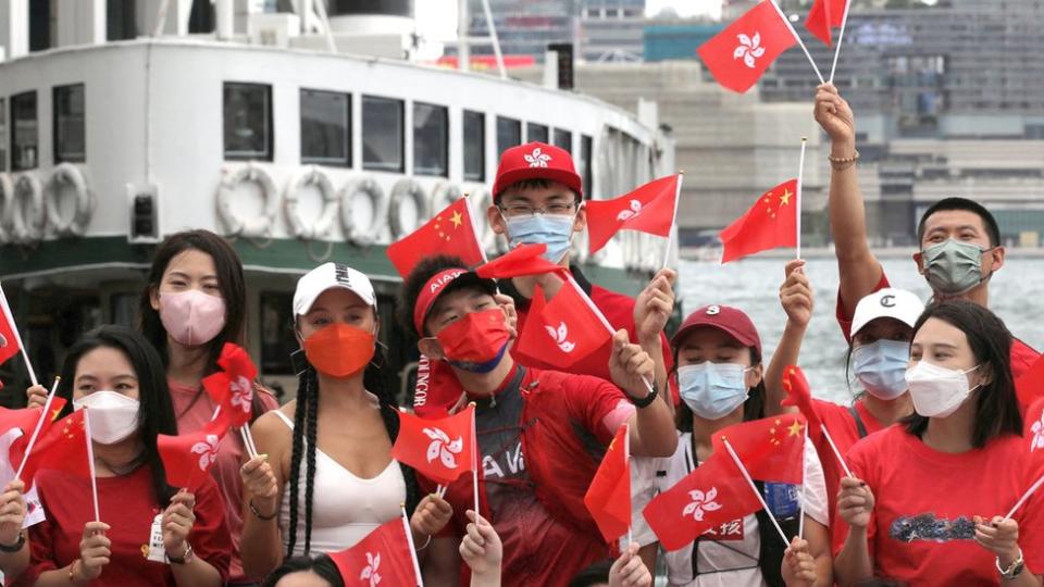 親政府青年群眾在香港中環海旁舉起中國國旗與香港區旗集體拍照（1/7/2022）