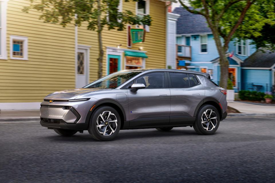 Driver’s side view of 2024 Chevrolet Equinox EV 1LT in Galaxy Gray Metallic driving down a road. Preproduction model shown. Actual production model may vary. 2024 Chevrolet Equinox EV available Fall 2023.