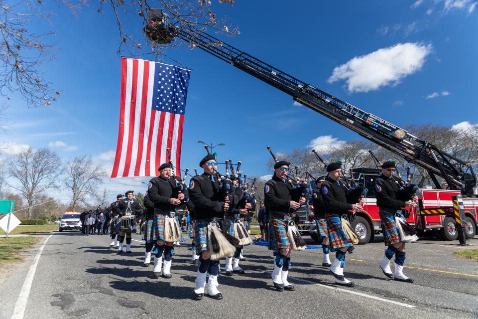 Band members escort the trophy as it enters Eisenhower Park in Nassau County on March 19, 2024.