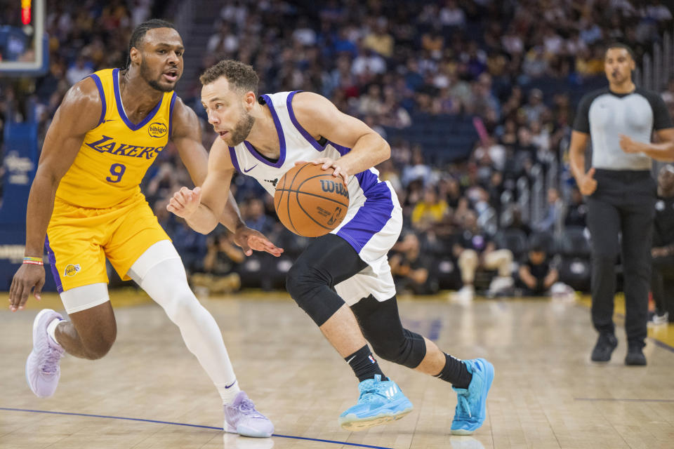 Sacramento Kings guard Jordan Ford, front right, dribbles past Los Angeles Lakers guard Bronny James (9) during the first half of an NBA summer league basketball game in San Francisco, Saturday, July 6, 2024. (AP Photo/Nic Coury)