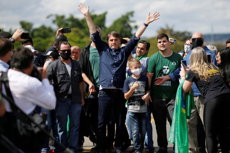 Brazil's President Jair Bolsonaro reacts during a meeting with supporters protesting in his favor in front of the Planalto Palace, amid the coronavirus disease (COVID-19) outbreak, in Brasilia