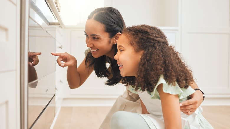 Mom and daughter looking through oven door