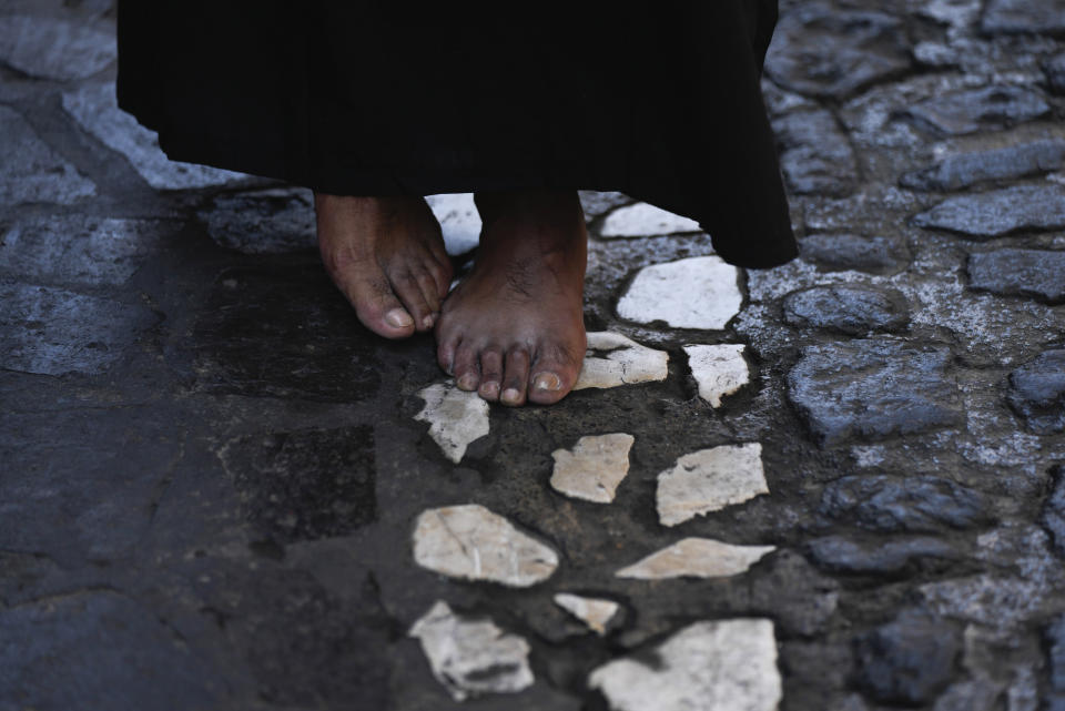 A bare-footed penitent walks in a Holy Week procession, in Taxco, Mexico, Thursday, March 28, 2024. (AP Photo/Fernando Llano)