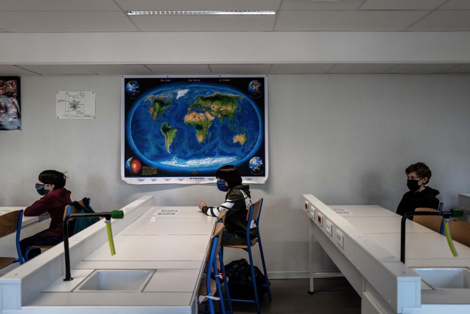 Schoolchildren wearing protective face masks attend a lesson in a middle school classroom, on May 18, 2020 in Lyon, central eastern France, after France eased lockdown measures to curb the spread of the COVID-19 pandemic, caused by the novel coronavirus. (Photo by JEFF PACHOUD / AFP) (Photo by JEFF PACHOUD/AFP via Getty Images)