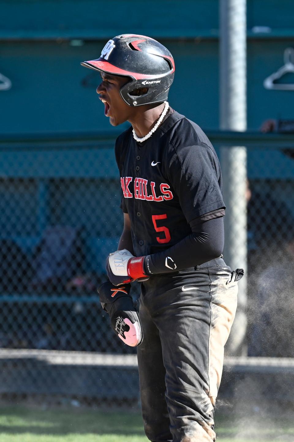 Oak Hills' Jacob Webster reacts after sliding into home safely to expand the lead against Sultana 2-0 on Monday, April 15, 2024 in Hesperia.