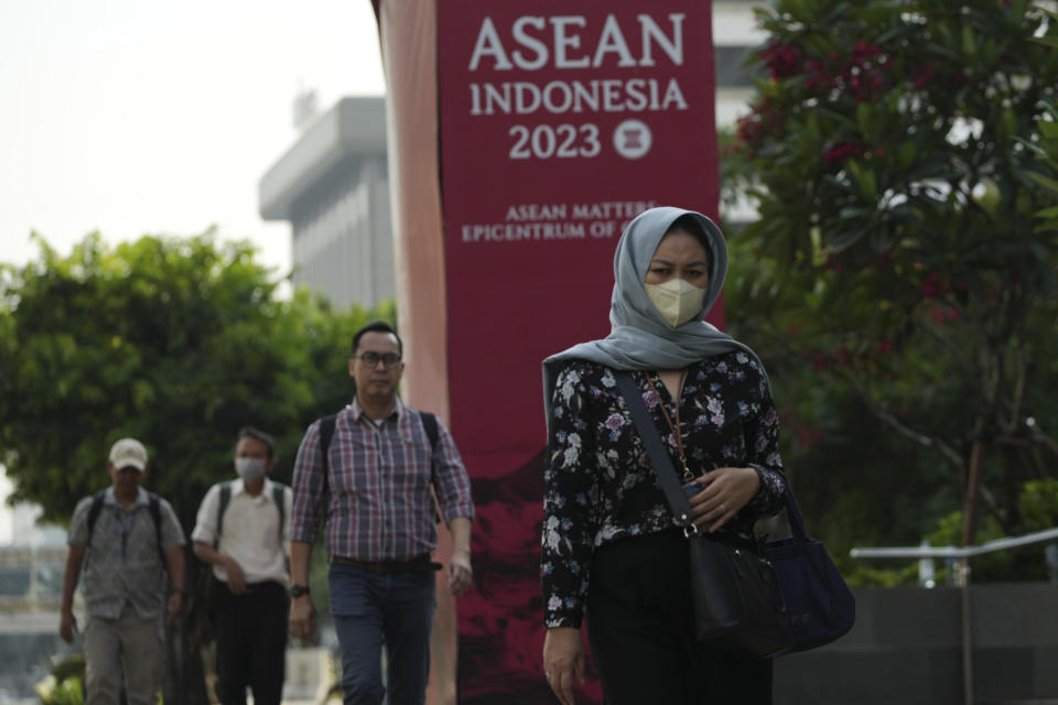 People walk past a banner for the Association of Southeast Asian Nations (ASEAN) foreign ministers' meeting in Jakarta, Indonesia, Monday, July 10, 2023. Myanmar's prolonged civil strife, tensions in the disputed South China Sea and concern over arms buildups in the region are expected to dominate the agenda when Southeast Asia's top diplomats gather for talks this week in Indonesia. (AP Photo/Achmad Ibrahim)