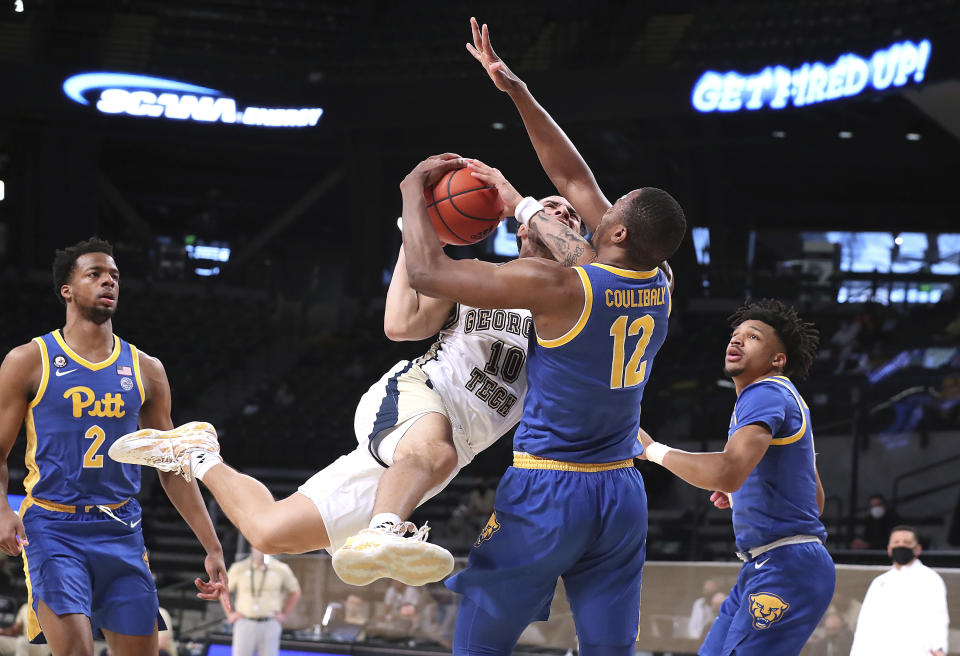 Georgia Tech guard Jose Alvarado is fouled by Pittsburgh forward Abdoul Karim Coulibaly (12) while driving to the basket during an NCAA college basketball game on Sunday, Feb. 14, 2021, in Atlanta. (Curtis Compton/Atlanta Journal-Constitution via AP)