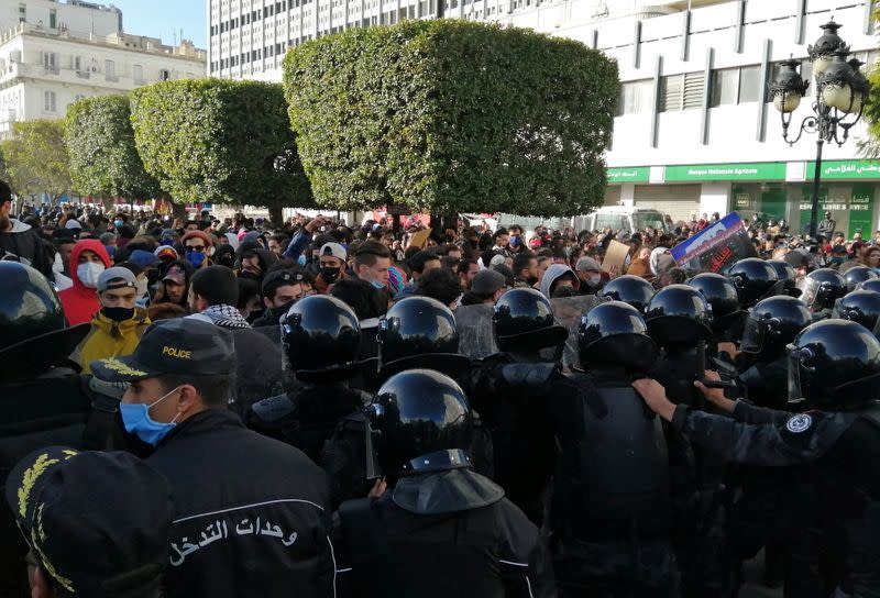 Police officers stand guard as demonstrators take part in an anti-government protest in Tunis