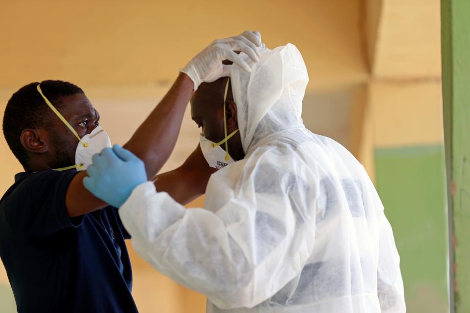 FILE PHOTO: A medical health worker helps his colleague to wear his PPE during a community testing, as authorities race to contain the spread of coronavirus disease (COVID-19) in Abuja, Nigeria April 15, 2020. REUTERS/Afolabi Sotunde