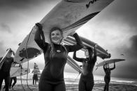 <p>After an exhausting but satisfying surfing lesson on a stormy spring afternoon, a group of teens on a class trip walks back from the ocean carrying their surfboards on their heads. (© Dotan Saguy) </p>