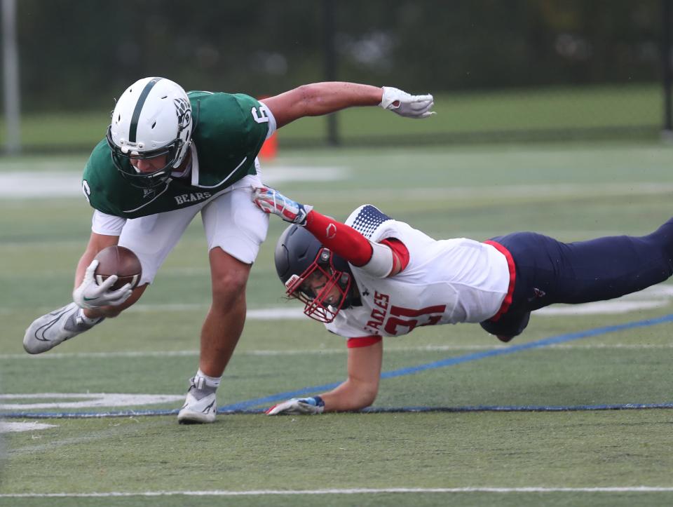 BrewsterÕs Colin LaMoreaux (6) gets slowed down by EastchesterÕs Vin Ciafone (21) during football action at Brewster High School Sept. 30, 2023. Eastchester won the game 21-0. 