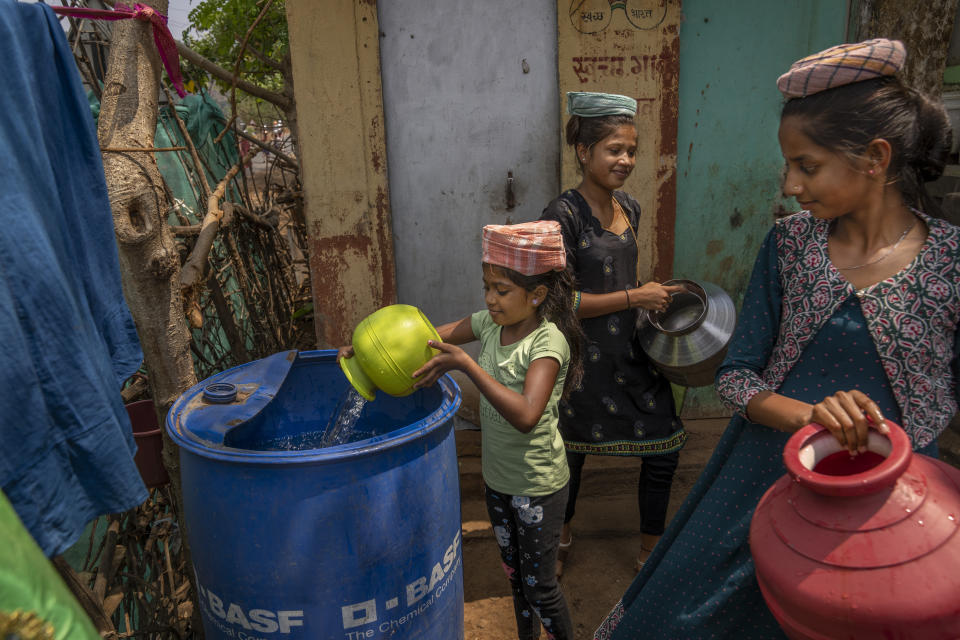 A girl empties a pot of water into a plastic container outside her home after collecting it from a nearby well in the village of Telamwadi, northeast of Mumbai, India, Saturday, May 6, 2023. Collecting water from wells is passed on from generation to generation, especially among women and girls in the rural villages. (AP Photo/Dar Yasin)