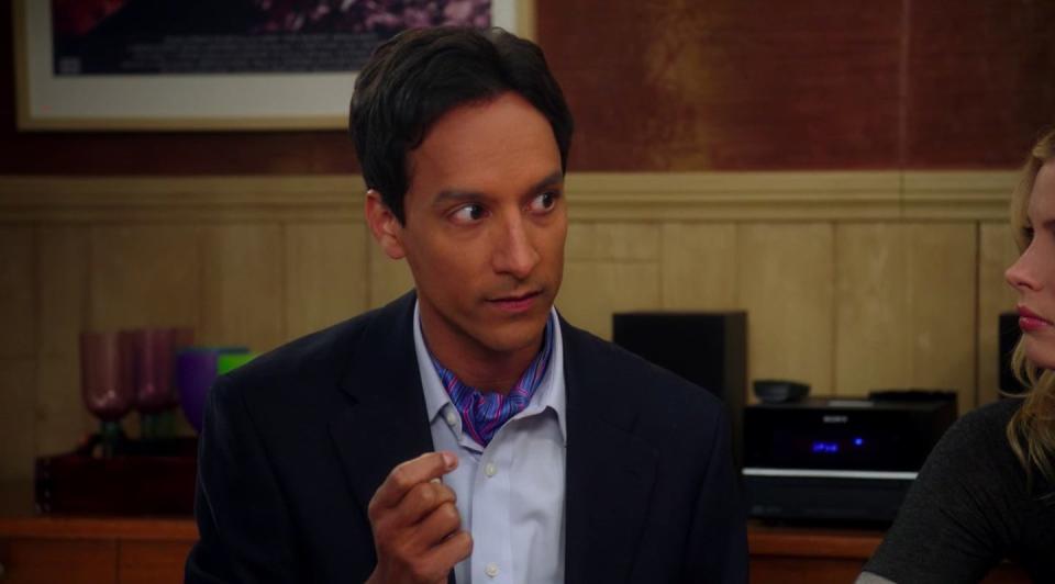 Abed holding a dice while sitting in his apartment in "Community"