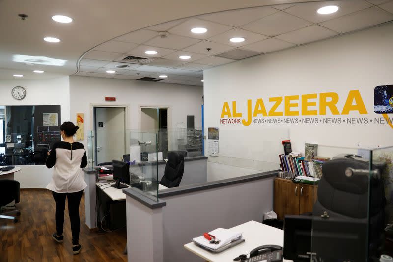 FILE PHOTO: An employee walks inside an office of Qatar-based Al-Jazeera network in Jerusalem