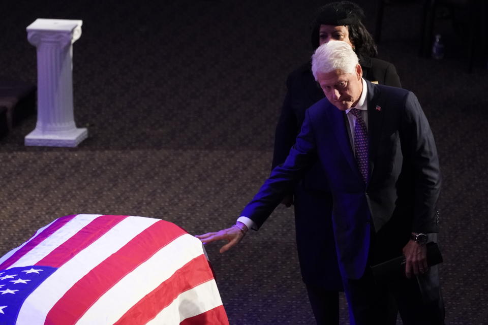 Former President Bill Clinton touches the flag-draped coffin of Rep. Elijah Cummings, D-Md., during his funeral service at the New Psalmist Baptist Church in Baltimore, Md., on Friday, Oct. 25, 2019. (Joshua Roberts/Pool via AP)