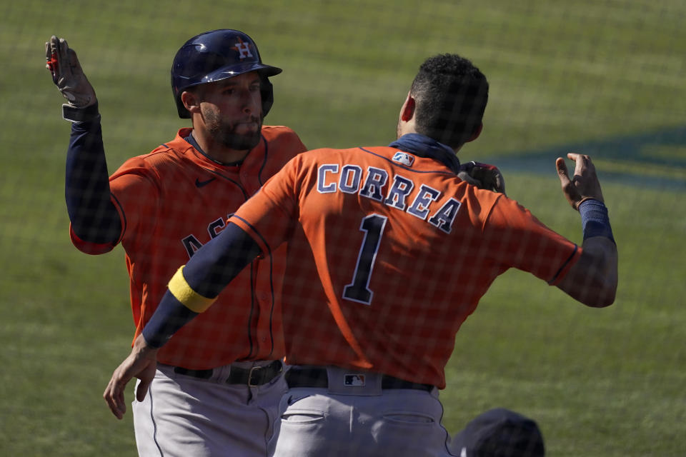 Houston Astros' George Springer, left, is congratulated by Carlos Correa after hitting a solo home run against the Oakland Athletics during the fifth inning of Game 2 of a baseball American League Division Series in Los Angeles, Tuesday, Oct. 6, 2020. (AP Photo/Ashley Landis)