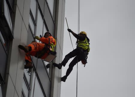 Specialists abseil down the side of Bray Tower to check the cladding, on the Chalcots Estate in north London, Britain, June 27, 2017. REUTERS/Hannah McKay