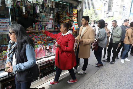 Customers line up to buy Mega Millions tickets at a newsstand in midtown Manhattan in New York, U.S., October 19, 2018. REUTERS/Mike Sugar