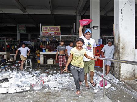 Vendors and shoppers run to safety after an earthquake hit Mandaue town in Cebu City, central Philippines October 15, 2013. REUTERS/Stringer