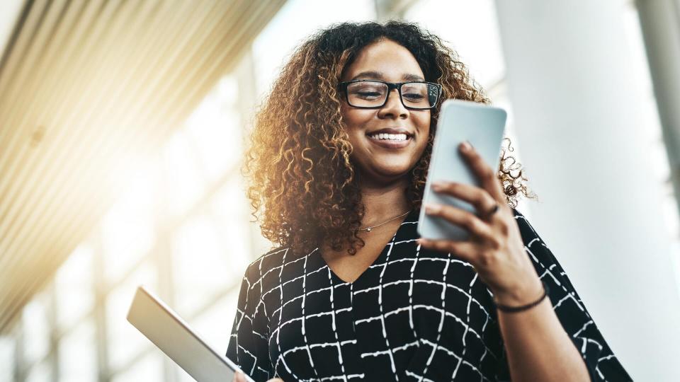 Low angle shot of an attractive young businesswoman using a smartphone in a modern office.