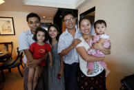 Reuters reporter Wa Lone poses with wife Pan Ei Mon and daughter, along with Reuters reporter Kyaw Soe Oo carrying his daughter next to wife Chit Su Win, after being freed from prison, after receiving a presidential pardon in Yangon, Myanmar, May 7, 2019. REUTERS/Ann Wang/Pool