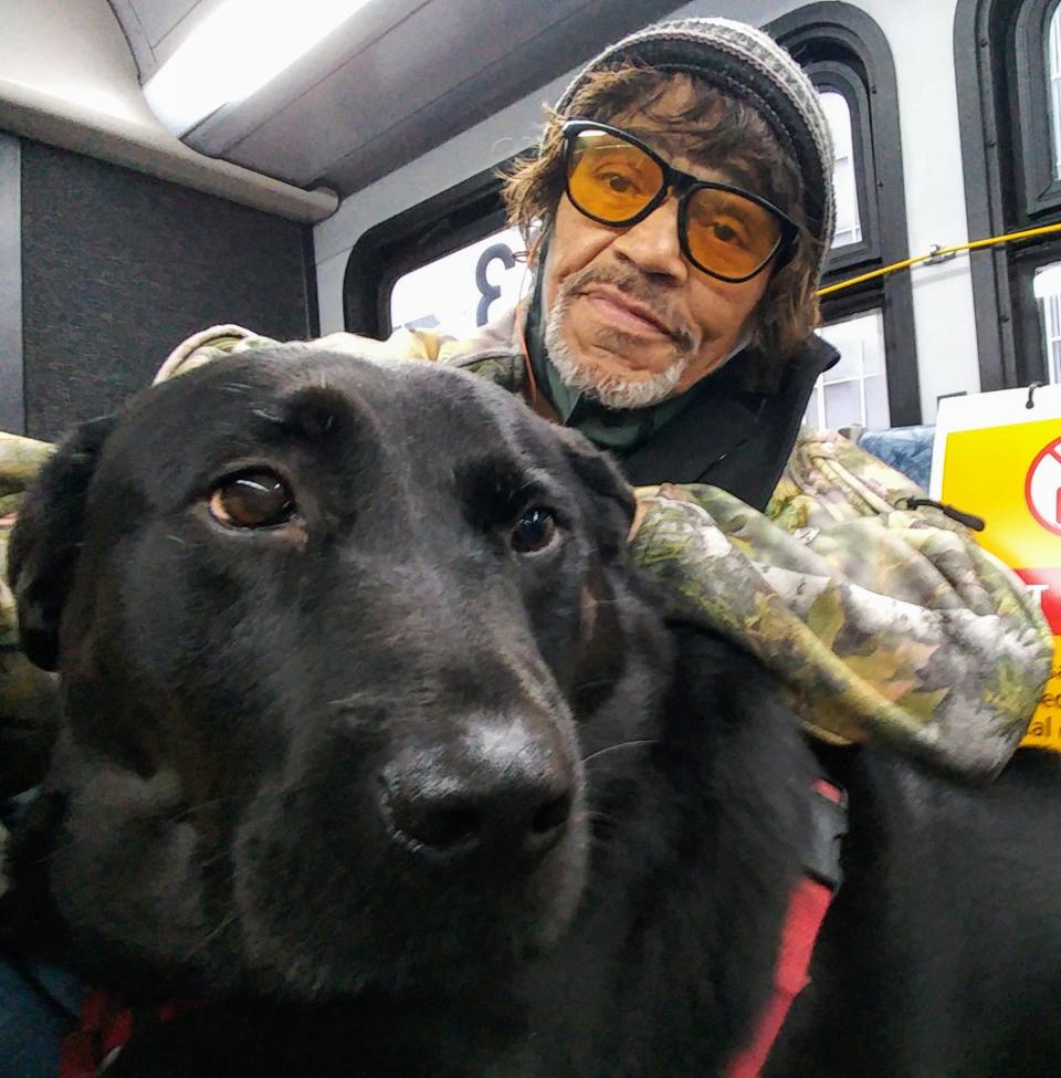 Jeff Young poses with his dog, Eclipse, while riding the bus in Seattle in March 2020. Eclipse died in her sleep at the age of 10 on Friday, October 14, 2022, according to her owner Jeff Young.