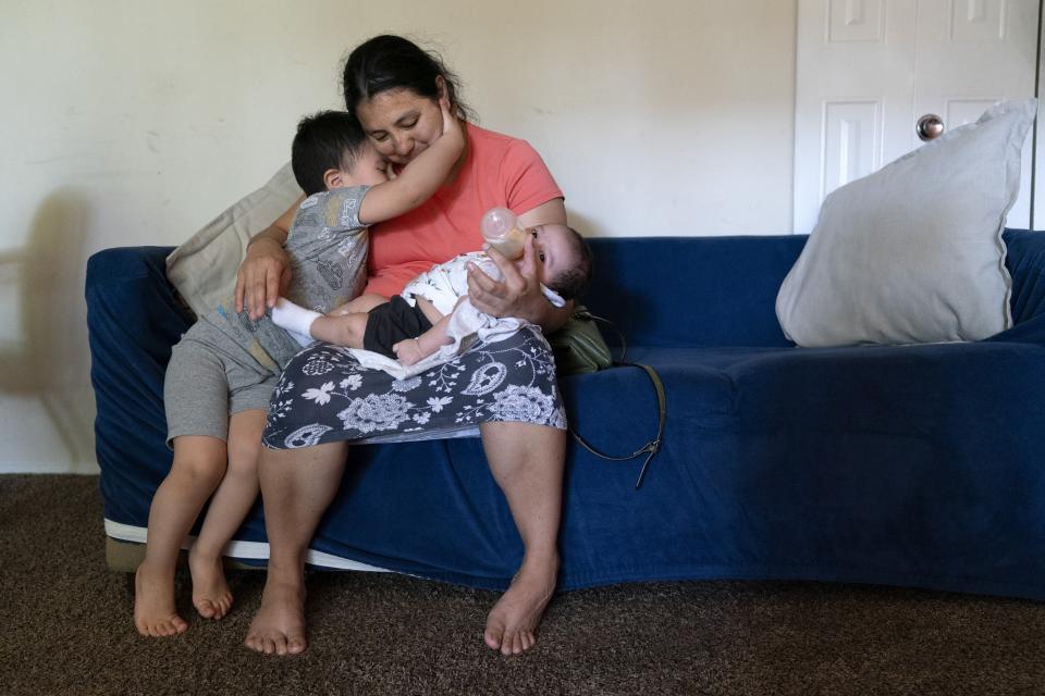 Jaasiel Galvaz, 2, hugs his mother, Yury Navas, 29, of Laurel, Md., as she feeds his two-month-old baby brother, Ismael Galvaz, with the only formula he can take without digestive issues, Enfamil Infant, from her dwindling supply of formula at their apartment in Laurel, Md., Monday, May 23, 2022. After this day's feedings she will be down to their last 12.5 ounce container of formula. Navas doesn't know why her breastmilk didn't come in for her third baby and has tried many brands of formula before finding the one kind that he could tolerate well, which she now says is practically impossible for her to find. To stretch her last can she will sometimes give the baby the water from cooking rice to sate his hunger. (AP Photo/Jacquelyn Martin)