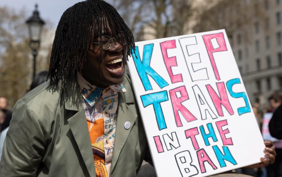 A demonstrator holds a placard during a No Ban Without Trans protest opposite Downing Street last year - Hollie Adams/Getty Images