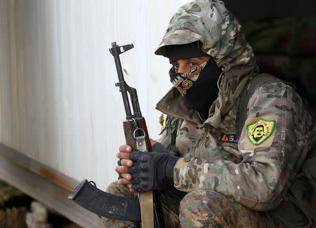 A fighter from the Syrian Democratic Forces (SDF) holds a weapon in the village of Baghouz, Deir Al Zor province, Syria March 17, 2019. REUTERS/Stringer