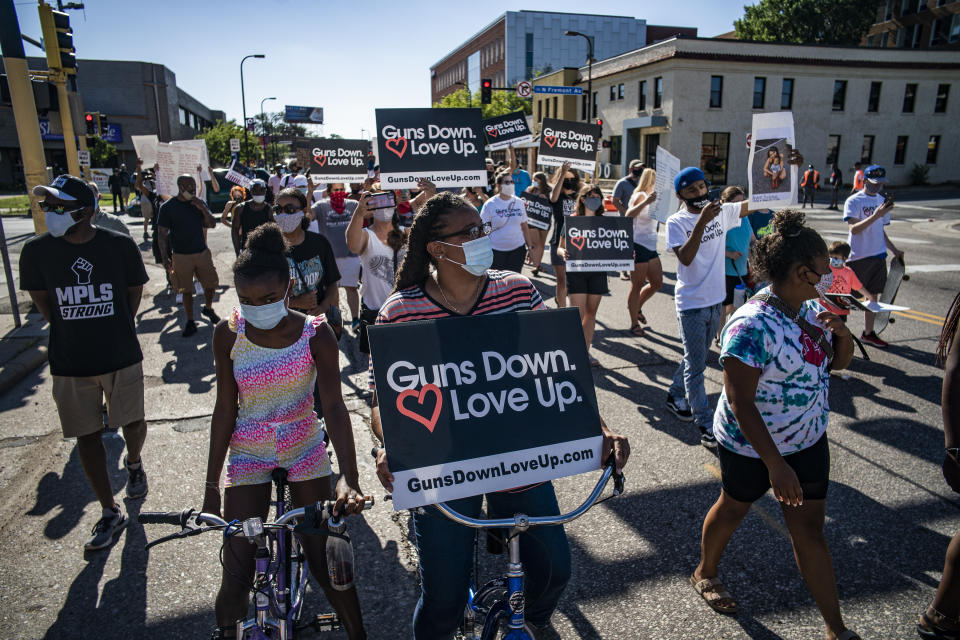 FILE - In this July 10, 2020, file photo, Savitta Ford and her daughter Harmony, 11, join a community rally in Minneapolis, calling for the end of gun violence in the Twin Cities. On Wednesday, Dec. 8, 2020, the Minneapolis City Council will decide whether to shrink the city's police department while violent crime is already soaring and redirect funding toward alternatives for reducing violence. (Richard Tsong-Taatarii/Star Tribune via AP, File)