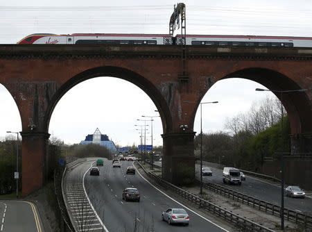 A Virgin London-bound train crosses the M60 motorway in Stockport, northern England, April 12, 2015. REUTERS/Andrew Yates