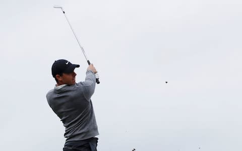 Rory McIlroy plays an iron shot - Credit: Reuters