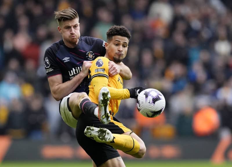 Wolverhampton Wanderers' Joao Gomes (R) and Luton Town's Reece Burke battle for the ball during the English Premier League soccer match between Wolverhampton Wanderers and Luton Town at Molineux Stadium. Nick Potts/PA Wire/dpa