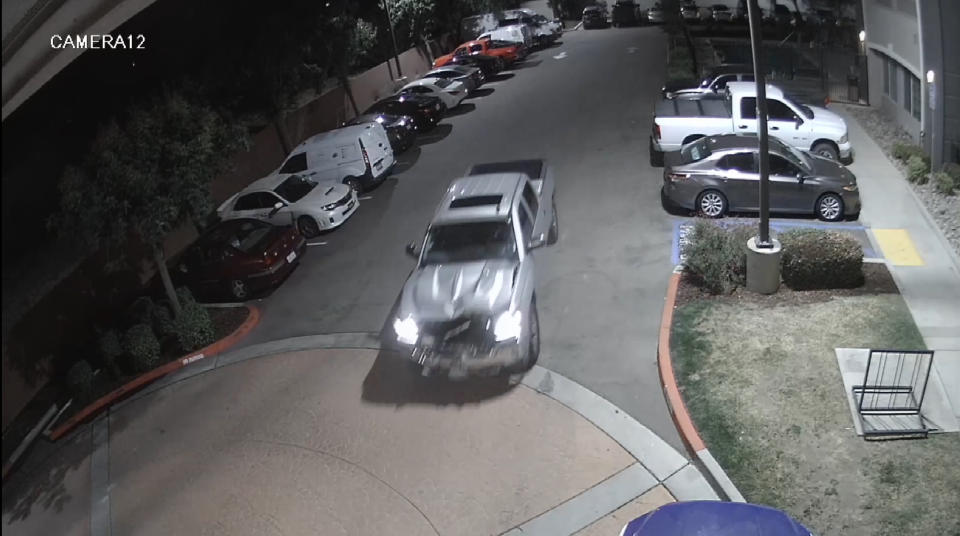 This surveillance video image released by the Fresno Police Department shows a pickup truck that struck a woman leaving a hotel parking lot in Fresno, Calif., Friday, May 13, 2022. Police in central California were searching for the driver of the pickup truck that struck a woman walking her dog Friday and kept going, dragging her more than 8 miles (13 kilometers) to the parking lot of a hotel, where her remains were found, (Fresno Police Department via AP)