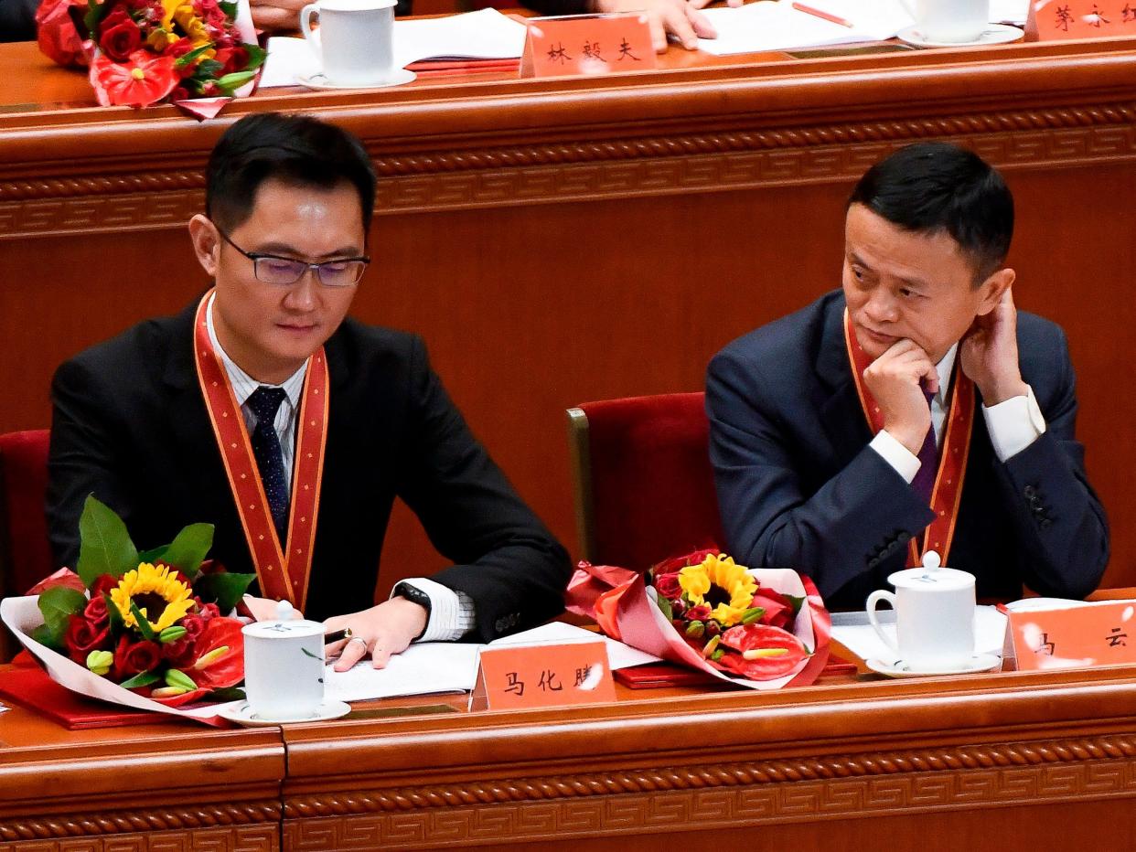 Alibaba's co-founder Jack Ma (R) looks at Tencent Holdings' CEO Pony Ma during a celebration meeting marking the 40th anniversary of China's "reform and opening up" policy at the Great Hall of the People in Beijing on December 18, 2018.