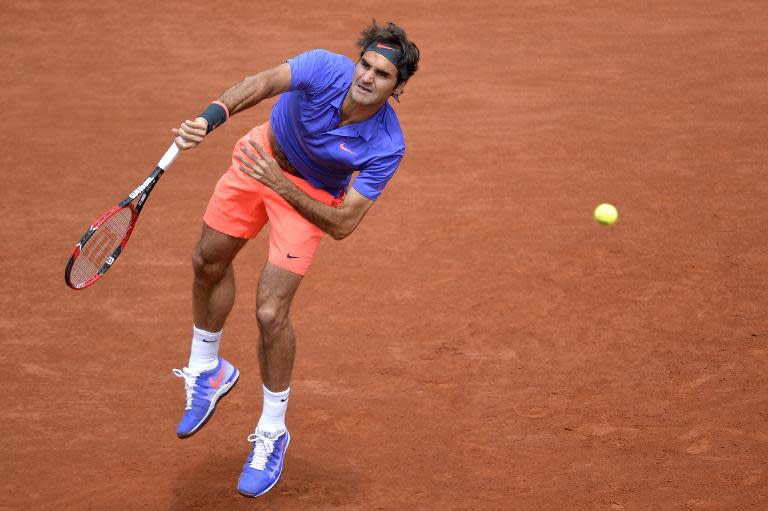 Switzerland's Roger Federer returns the ball to Bosnia-Herzegovina's Damir Dzumhur during the men's third round at the Roland Garros 2015 French Tennis Open in Paris on May 29, 2015