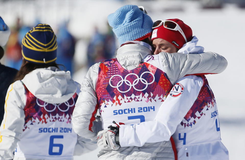 Norway's gold medal winner Marit Bjoergen hugs her compatriot bronze medal winner Heidi Weng after the women's cross-country 15k skiathlon at the 2014 Winter Olympics, Saturday, Feb. 8, 2014, in Krasnaya Polyana, Russia. (AP Photo/Dmitry Lovetsky)