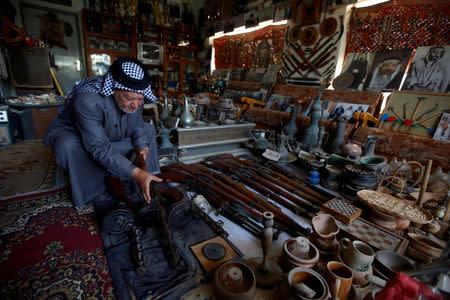 Youssef Akkar, 80, an Iraqi retired teacher holds an old weapon in his museum at home in Najaf, Iraq February 18, 2019. REUTERS/Alaa al-Marjani