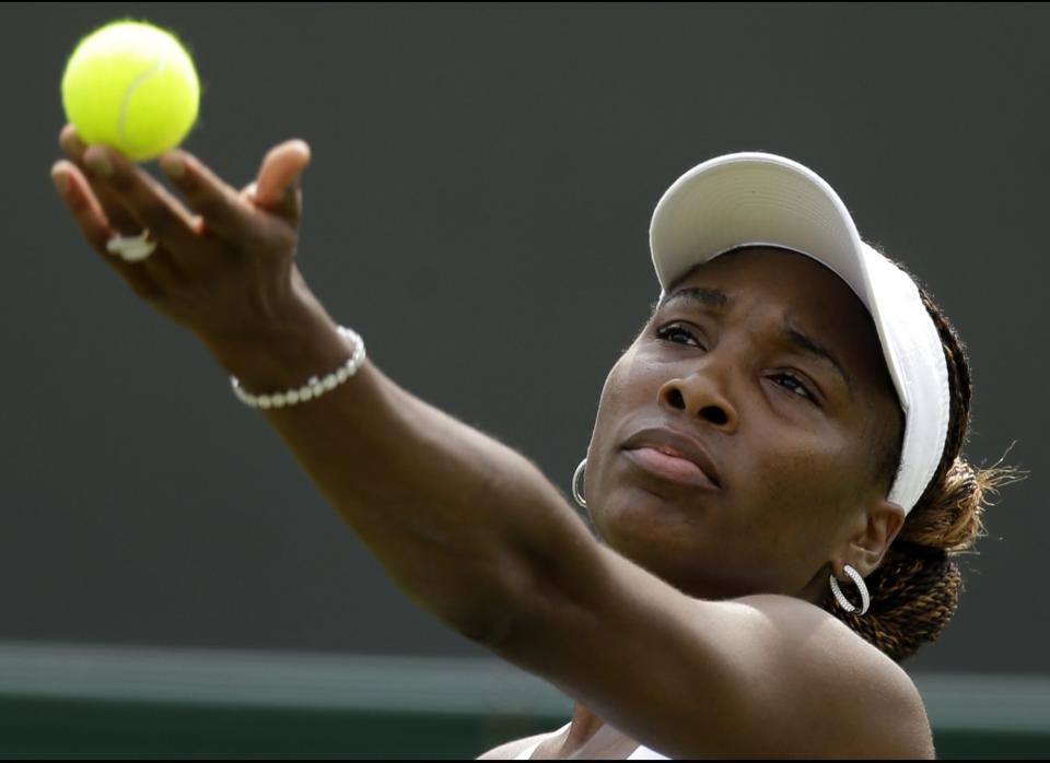 Venus Williams of the United States tosses the tennis ball to serve to Elena Vesnina of Russia during a first round women's singles match at the All England Lawn Tennis Championships at Wimbledon, England, Monday, June 25, 2012.