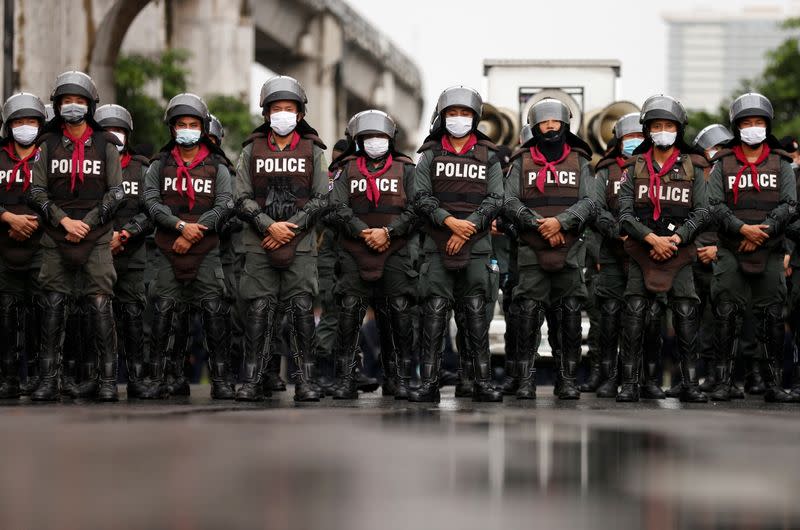 Police officers stand in line as they close the road near Ratchaprasong junction, in Bangkok