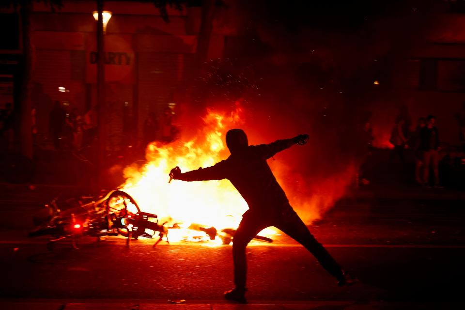 A protester throws a projectile near burning bicycles  at the Place de la Republique (REUTERS/Yara Nardi)