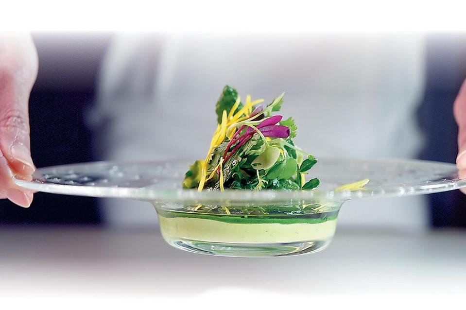 〈花蛤山菜綠沙拉〉是用茼蒿花（可食菊花）搭配花蛤，以及「植物界最高級奶油」酪梨使口感滑順，盤內一同上桌的還有過貓、皇宮菜、綠羽衣和川七花等山菜。圖／姚舜