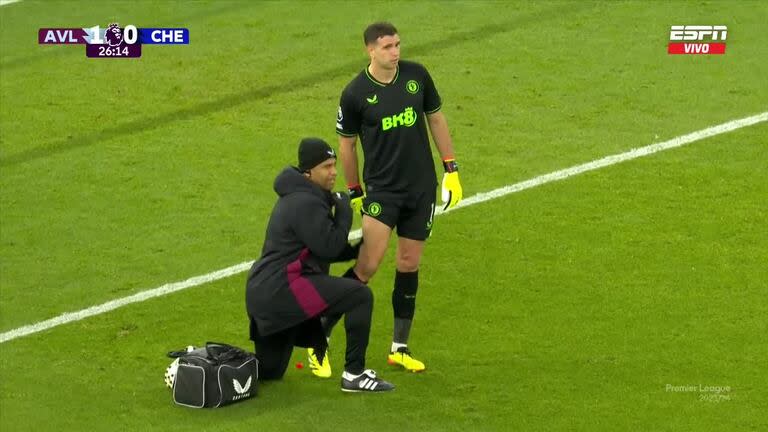 Dibu Martínez, atendido en su muslo derecho durante el partido con Chelsea; finalmente, debió salir reemplazado