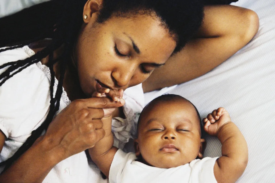 young mom kissing her baby's hand