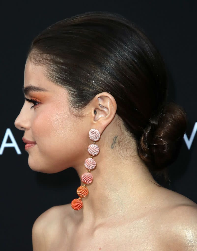 <p>Behind her right ear, Gomez has the initial 'G' tatttooed, which according to <a href="https://pagesix.com/list/selena-gomezs-tattoos-complete-guide-to-all-of-their-meanings/" rel="nofollow noopener" target="_blank" data-ylk="slk:Page Six;elm:context_link;itc:0;sec:content-canvas" class="link ">Page Six</a> is in honour of her little sister Gracie. </p>