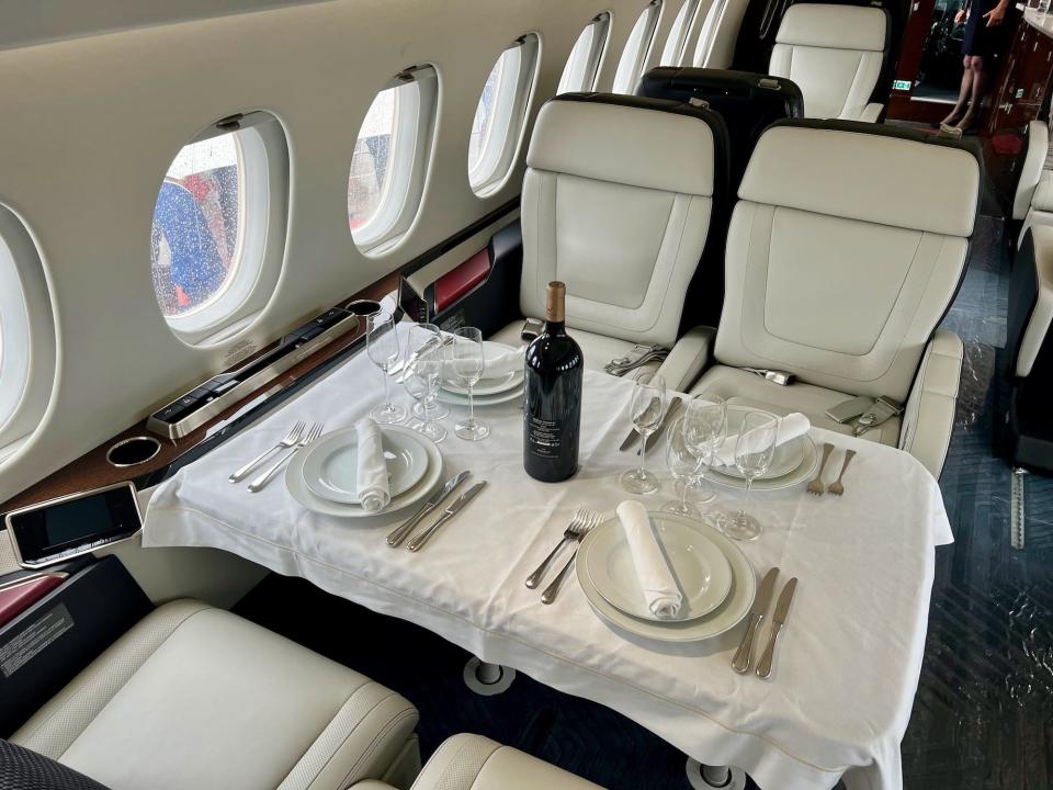 The dining room fully set up with tablecloth and dining ware onboard the 6X.