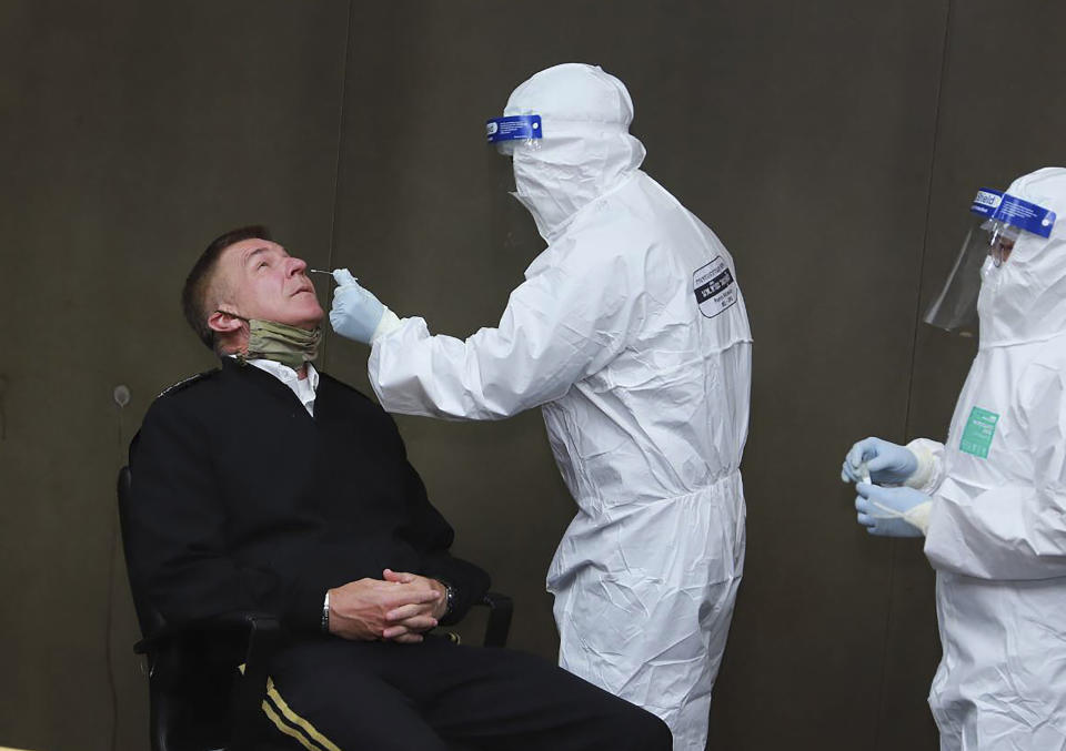 In this photo released by the Royal Thai Army, a health officer collects a nasal swab sample from Chief of Staff of the U.S. Army Gen. James McConville to test for the coronavirus at the military airport in Bangkok, Thailand, Thursday, July 9, 2020. McConville will be the first official foreign guest to meet Thailand's Prime Minister Prayuth Chan-ocha at the Government House since travel restrictions were eased for a select group of foreigners allowed to visit Thailand. (Royal Thai Army via AP)