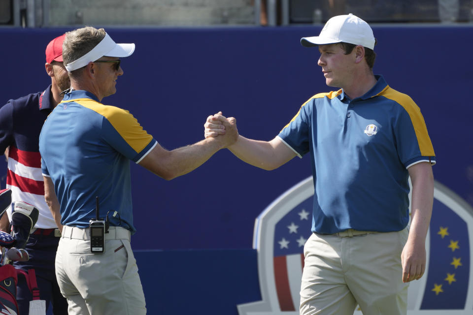 Europe's Robert Macintyre, right, shoes hand with Europe's Team Captain Luke Donald on the 1st tee during his singles match at the Ryder Cup golf tournament at the Marco Simone Golf Club in Guidonia Montecelio, Italy, Sunday, Oct. 1, 2023. (AP Photo/Alessandra Tarantino)