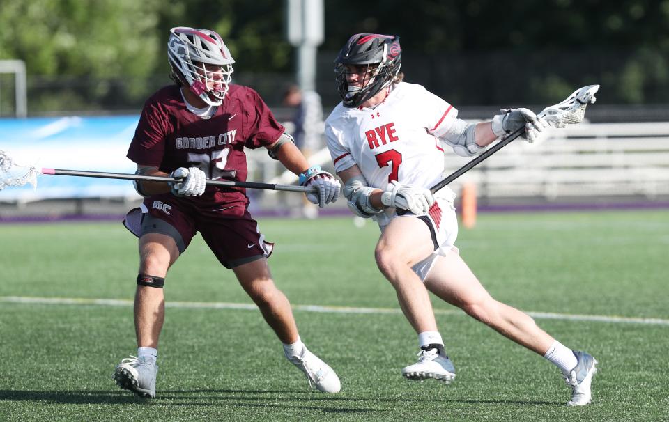 Rye's Kian McCarthy (7) tries to drive to the goal in front of Garden City's Ryan McKenna (23) during the boys lacrosse Class B state semifinal at University of Albany June 8, 2022.  Garden City won the game 6-4.